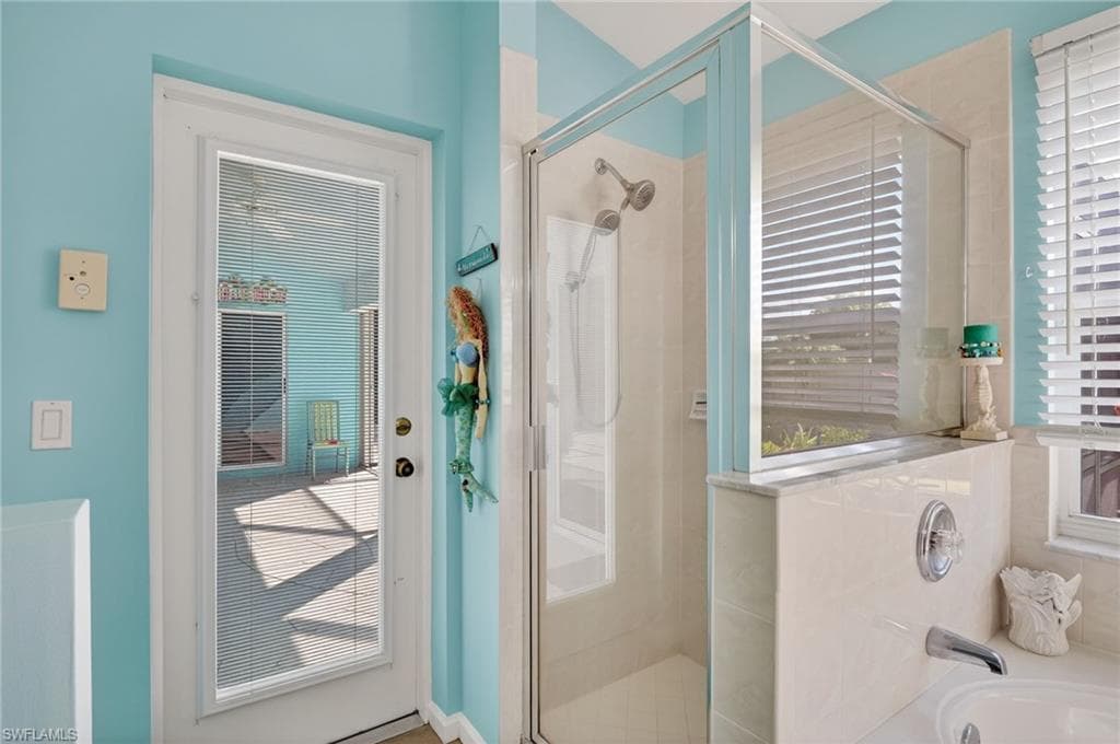 Full bath with a shower stall and a bath