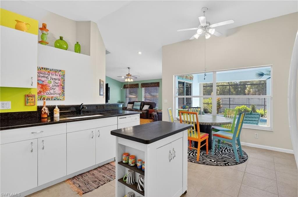 Kitchen with white cabinetry, ceiling fan, open floor plan, light tile patterned floors, and open shelves