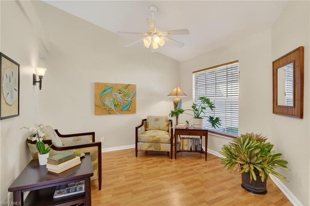 Living area featuring light wood-style flooring, lofted ceiling, and a ceiling fan