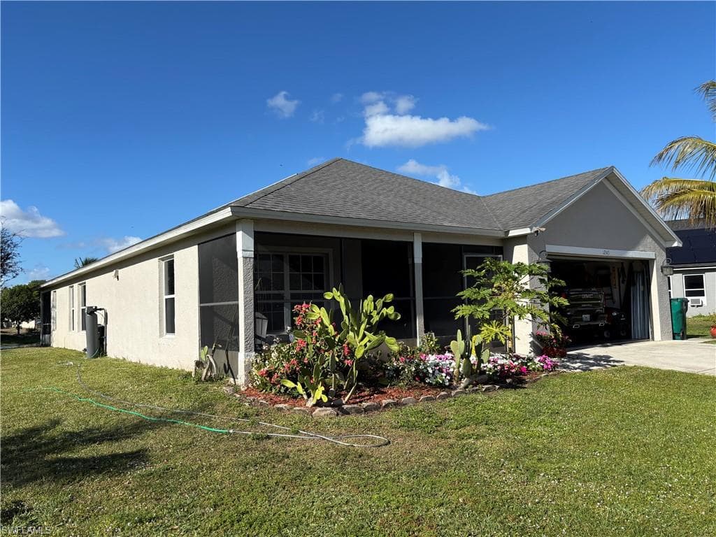 View of home's exterior with a lawn, a shingled roof, an attached garage, stucco siding, and driveway