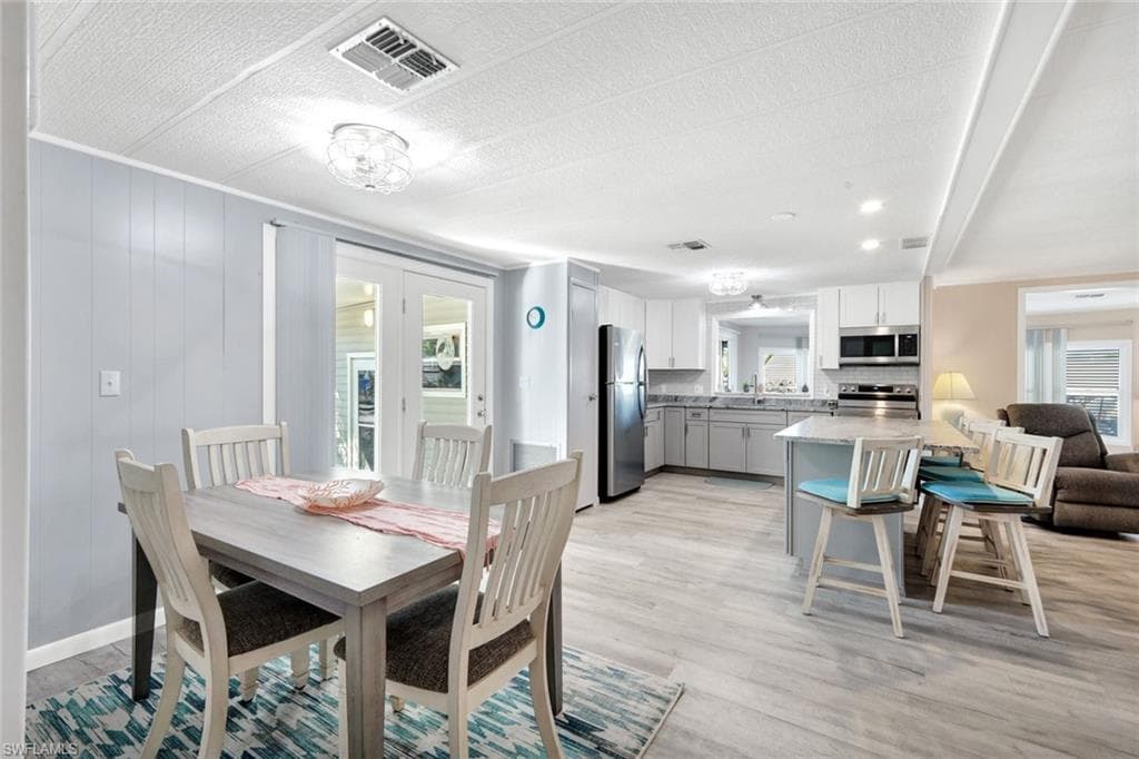Spacious primary bedroom featuring soothing coastal colors, abundant natural light, and luxury vinyl flooring.