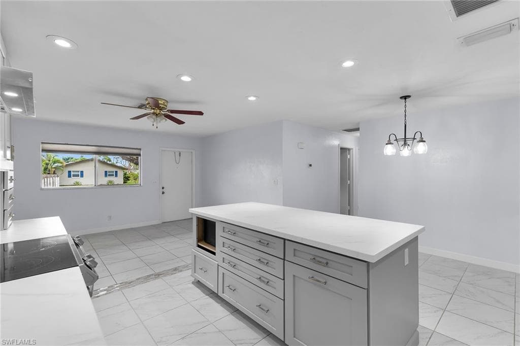 Kitchen featuring recessed lighting, a center island, hanging light fixtures, gray cabinets, and range with electric cooktop