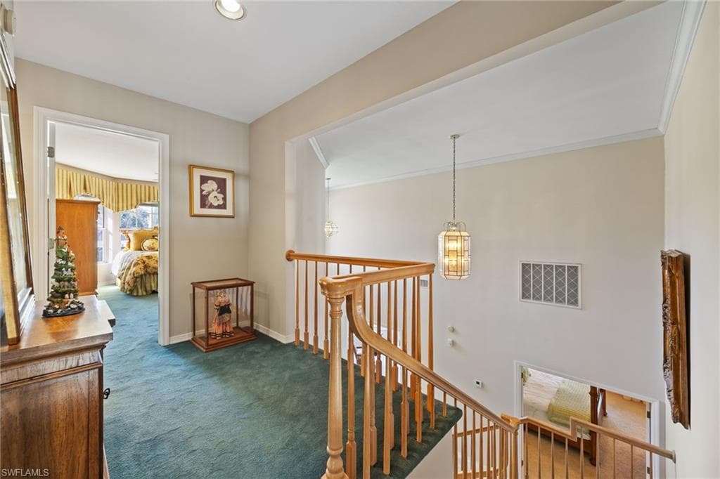 Hallway with an upstairs landing and a chandelier