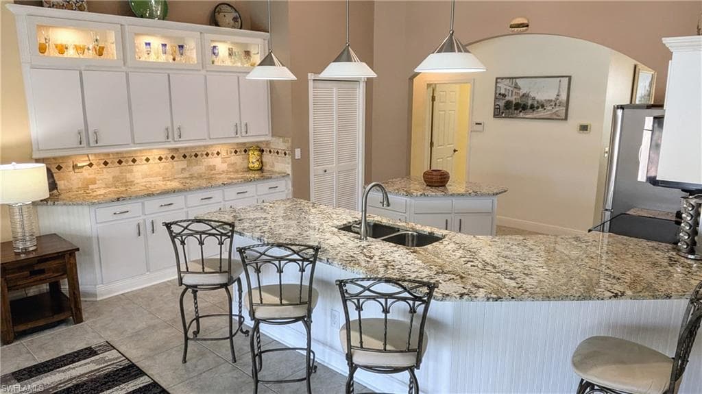 The 42 inch Lighted Kitchen Cabinets & Under Cabinet Lighting Showcases the magnificent Granite Counters and Stone Backsplash