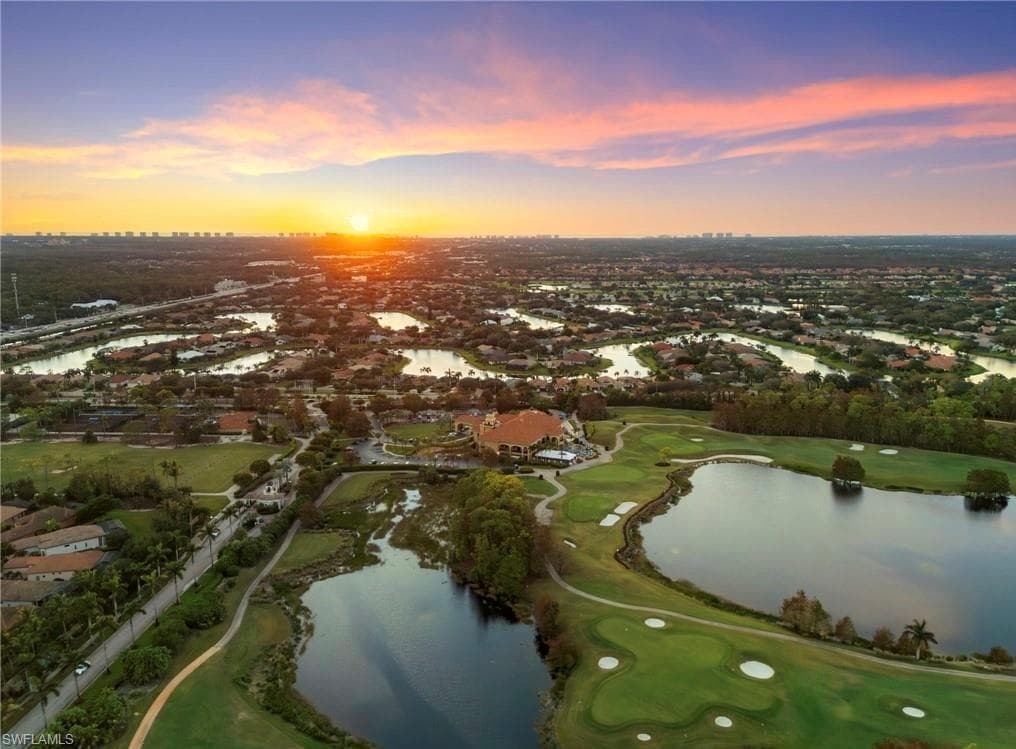 Aerial view of residential area featuring a golf club and a large body of water