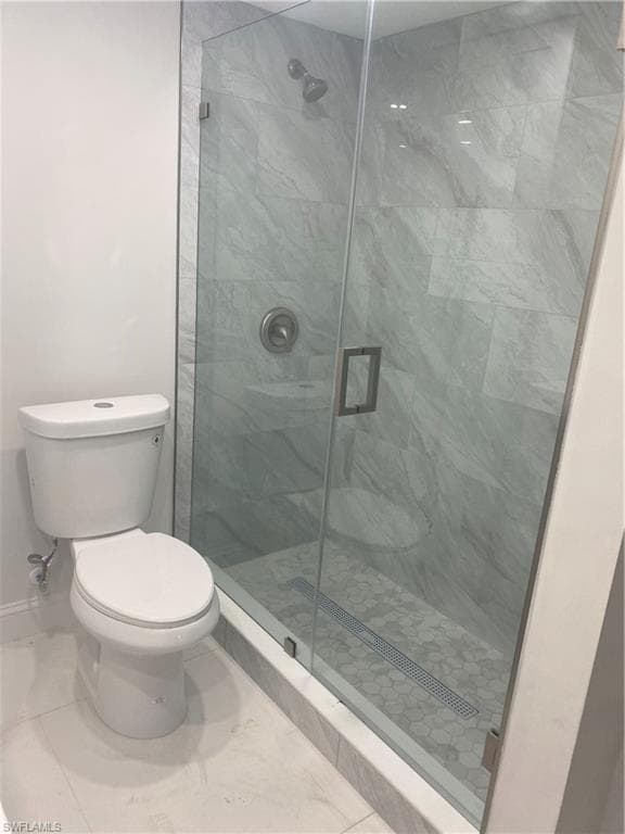 Bathroom featuring a stall shower and marble finish floors