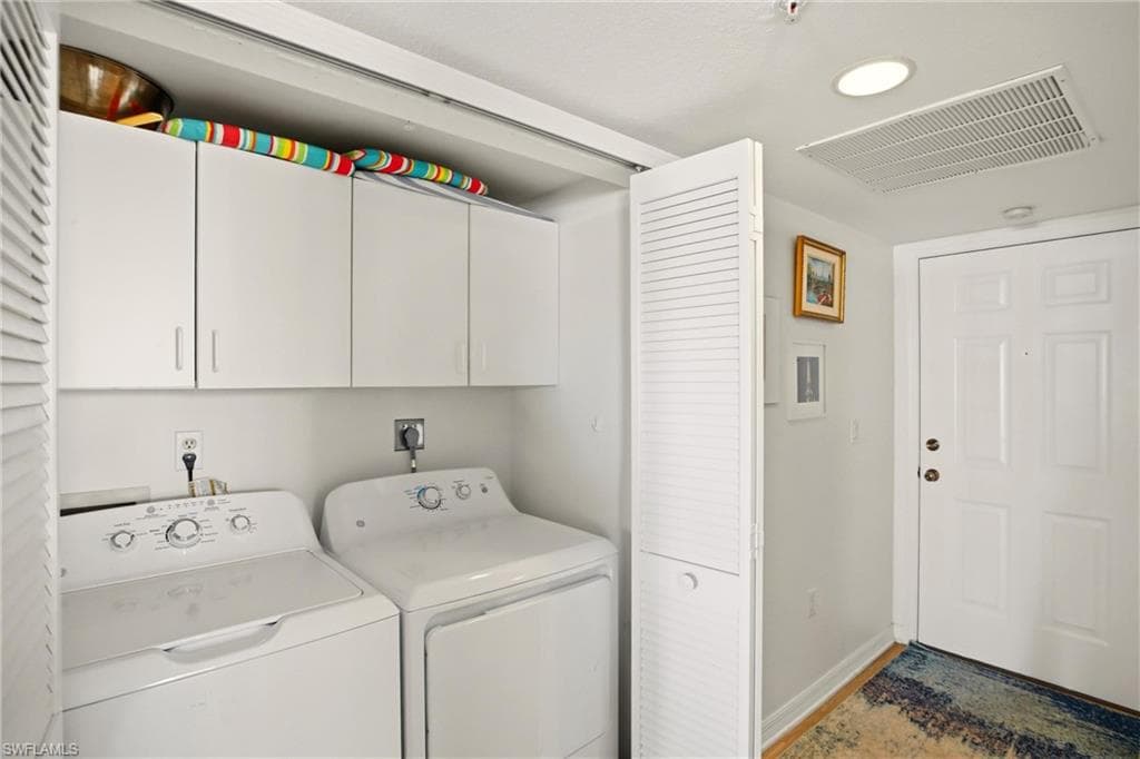 The laundry area offers cabinets for storage.
