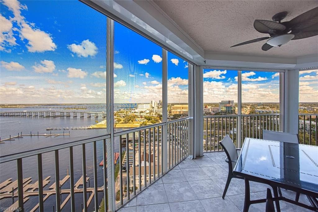 Sunroom with a textured ceiling, tile patterned flooring, and a water view