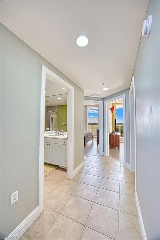 Hallway with light tile patterned floors and recessed lighting