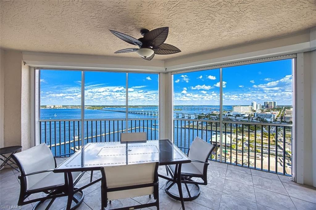 Sunroom featuring a water view and a textured ceiling