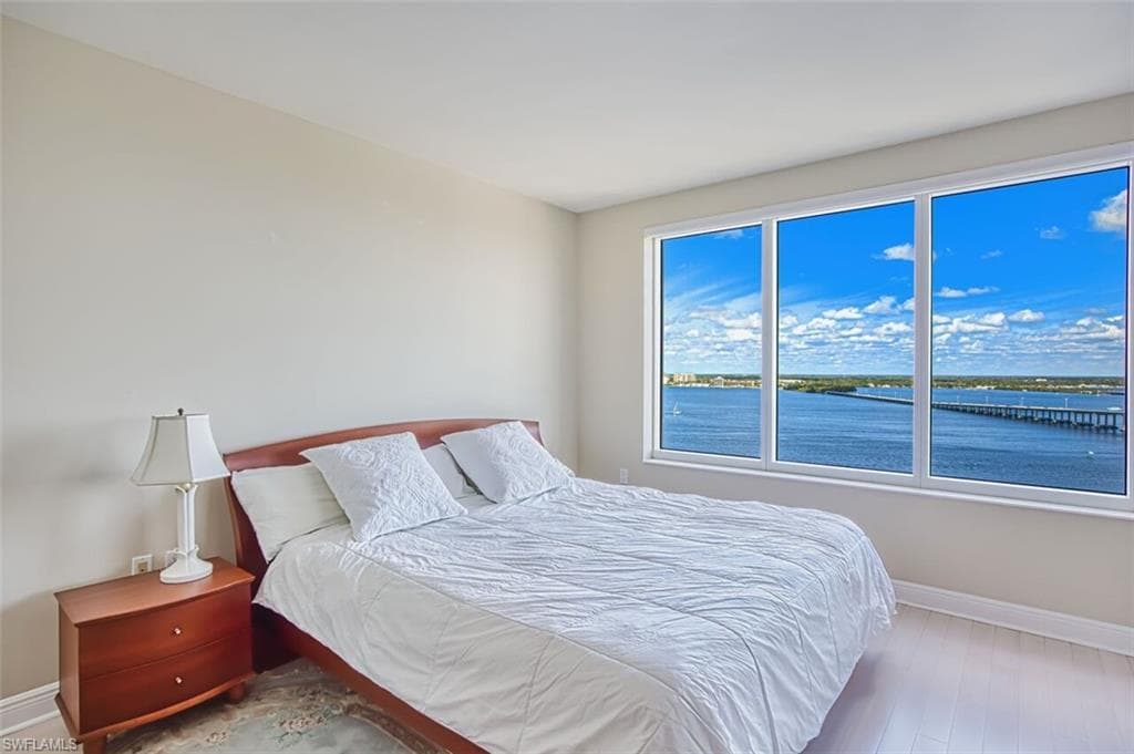 Bedroom featuring baseboards and a water view