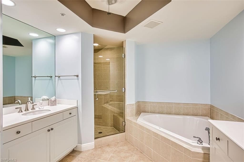 Full bathroom featuring vanity, a shower stall, light tile patterned floors, a garden tub, and recessed lighting