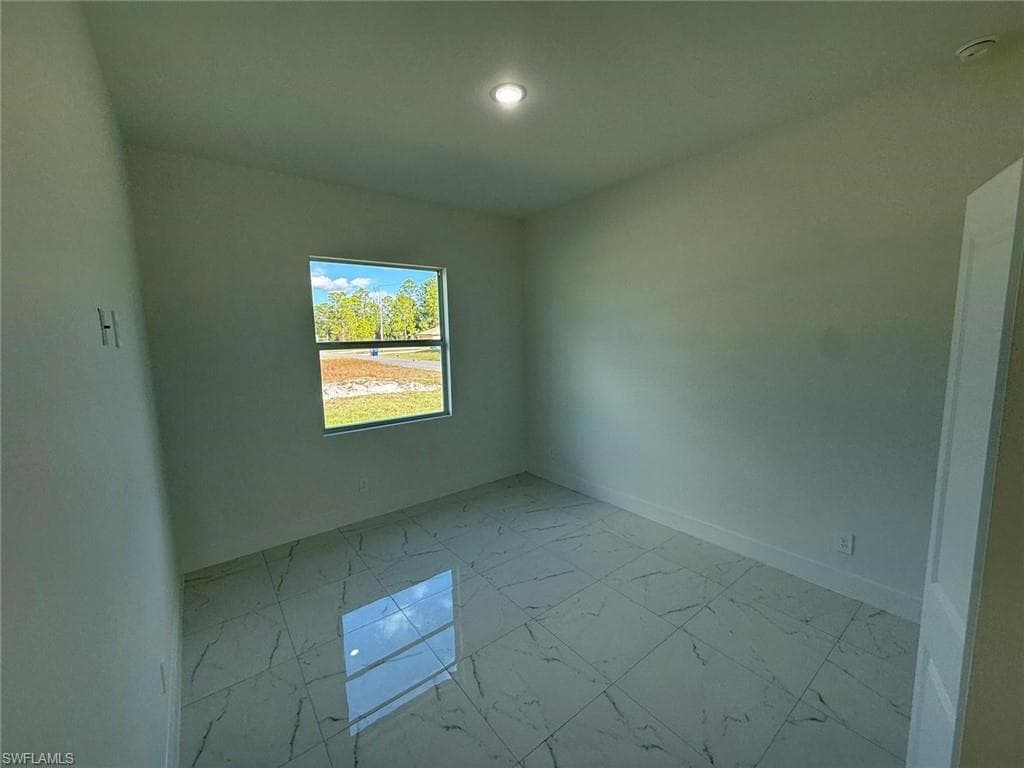 Unfurnished room with light marble finish flooring and baseboards