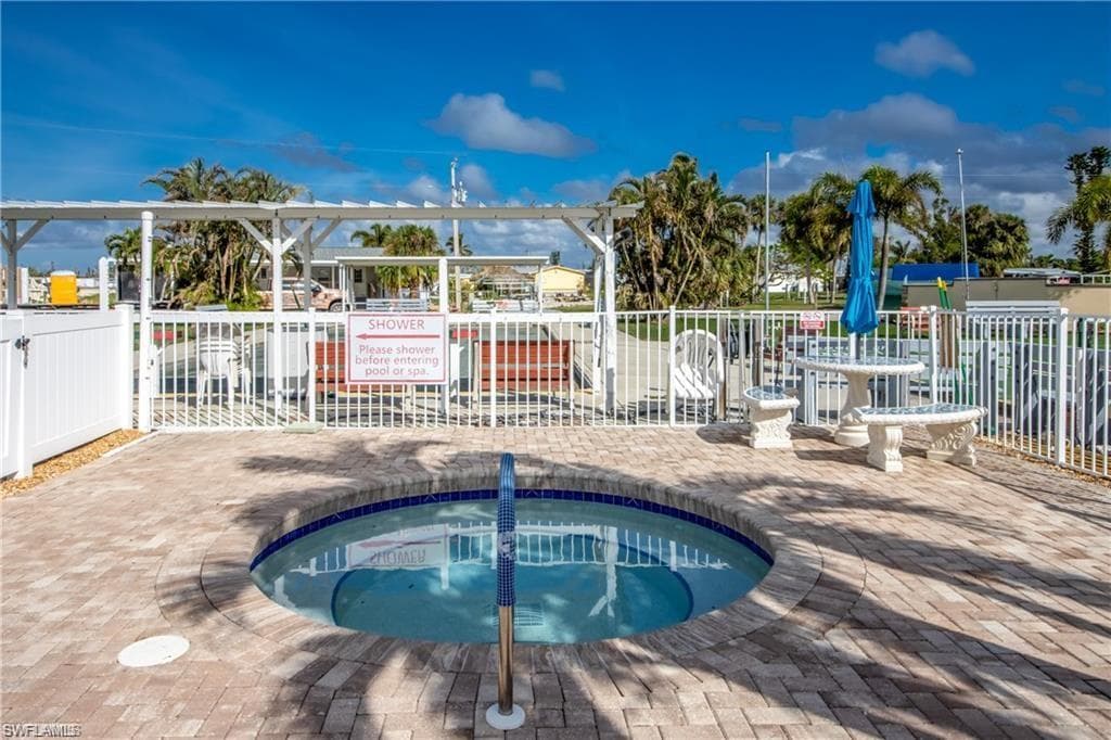 View of swimming pool with a community hot tub, a pool, and a patio area