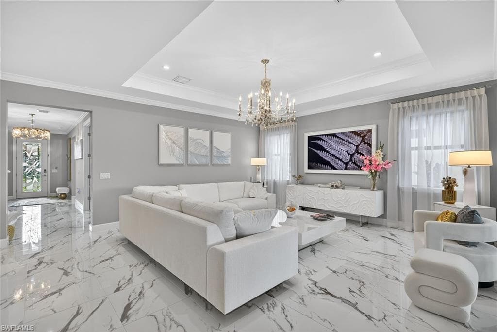 Living area featuring a chandelier, crown molding, healthy amount of natural light, light marble finish flooring, and recessed lighting