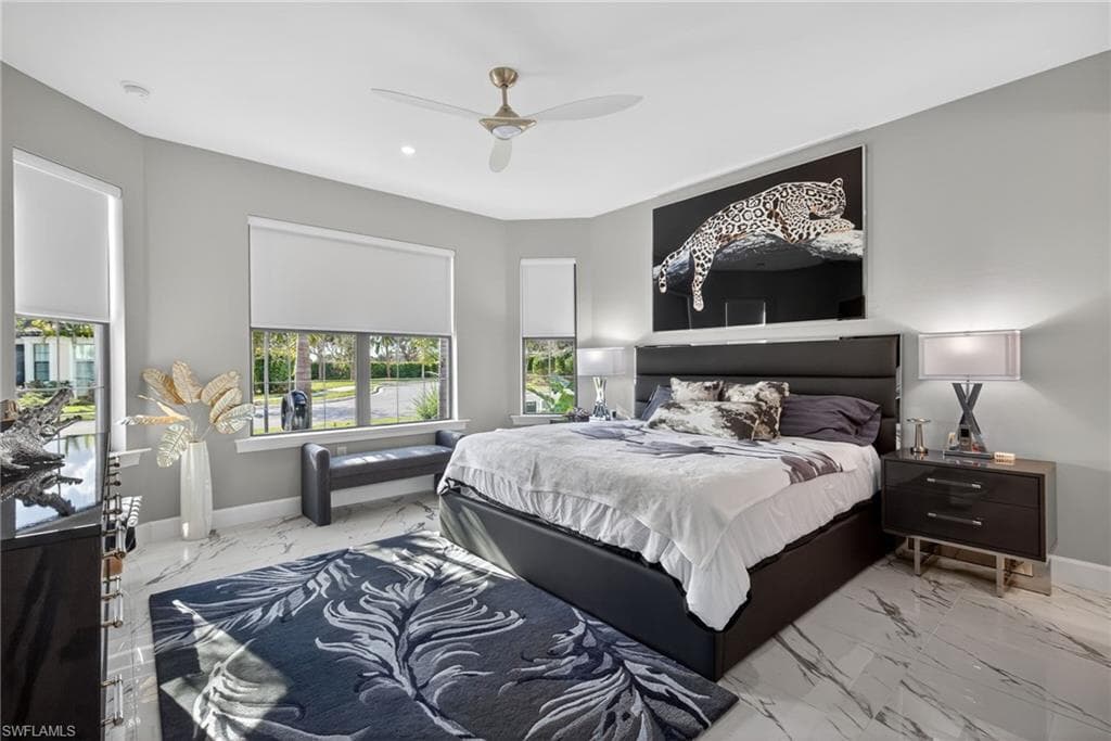 Bedroom featuring a ceiling fan and marble finish floors