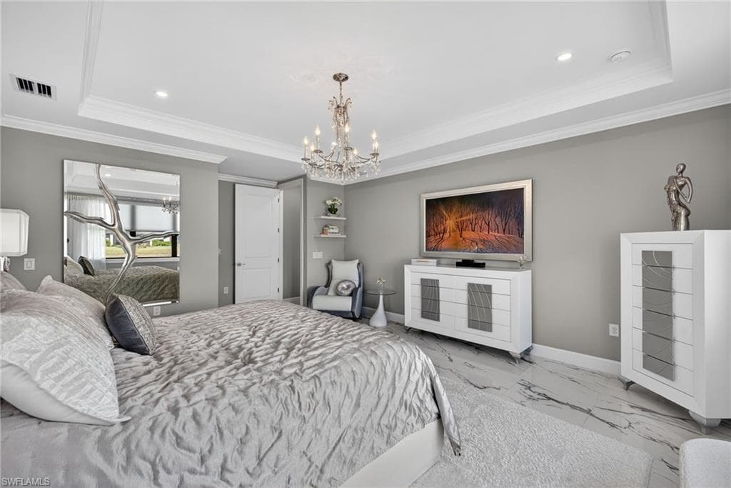 Bedroom with a chandelier, a raised ceiling, marble look tiles, ornamental molding, and recessed lighting