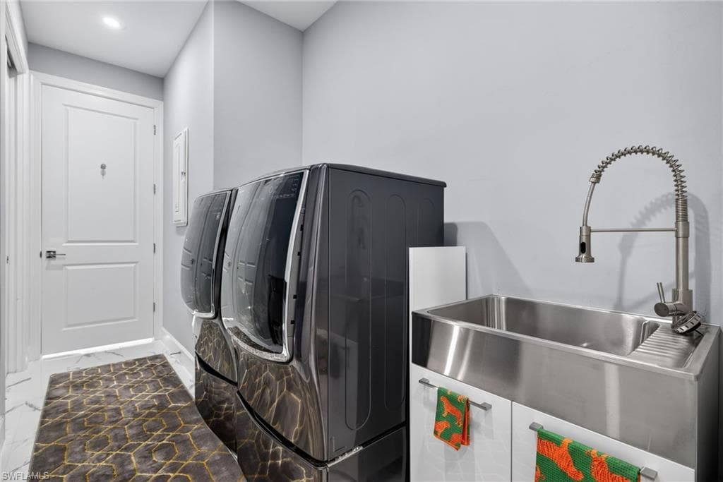 Washroom featuring washing machine and dryer and stone finish flooring
