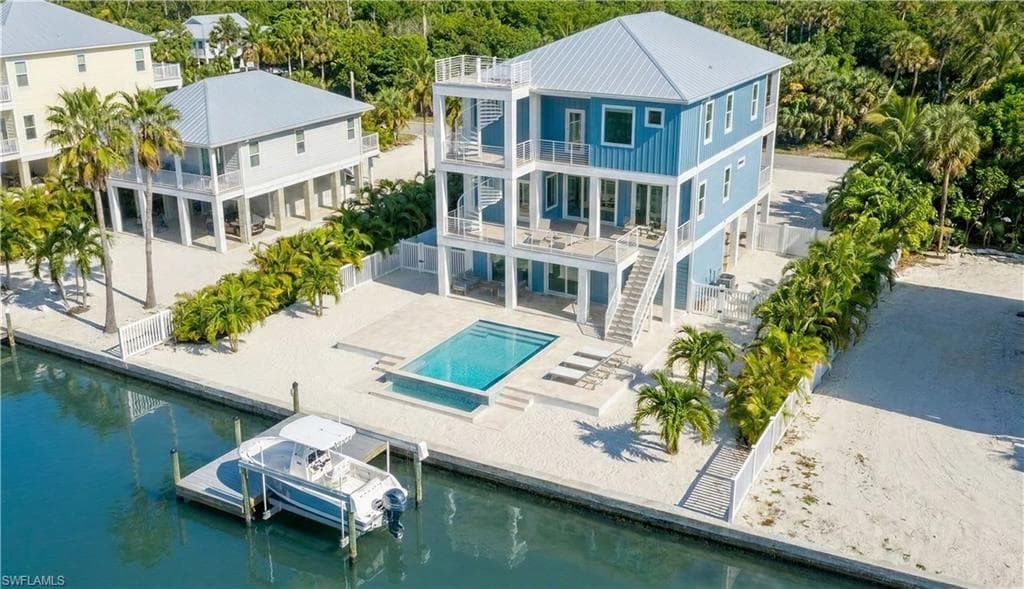 Rear 3D rendering of house with pool area, expansive decks & multiple levels, gulf access canal - virtually enhanced