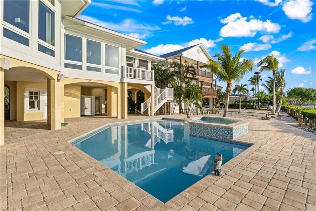 Soak up the Florida lifestyle in this stunning outdoor retreat, complete with a crystal-clear pool, elevated spa, and sun-drenched paver patio framed by swaying palms.