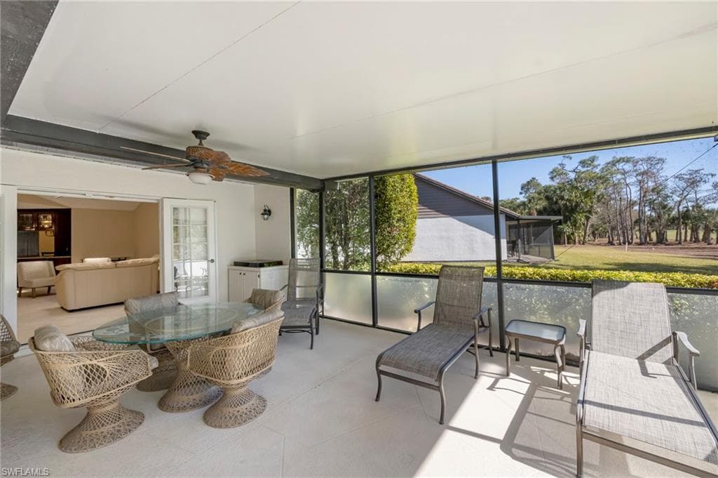 Sunroom / solarium featuring outdoor dining area and a ceiling fan