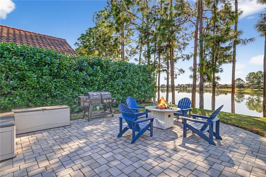 View of patio featuring a fire pit, a water view, and grilling area