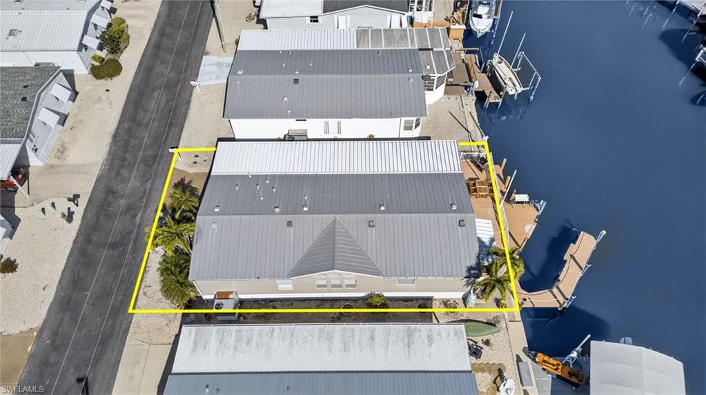 Aerial view of property and surrounding area featuring a large body of water and property boundaries highlighted
