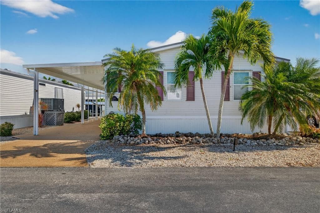 Manufactured / mobile home featuring driveway and an attached carport