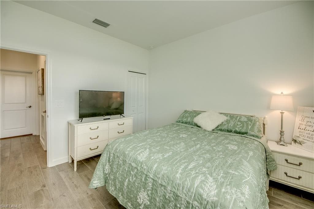 Bedroom featuring wood finish floors and a closet