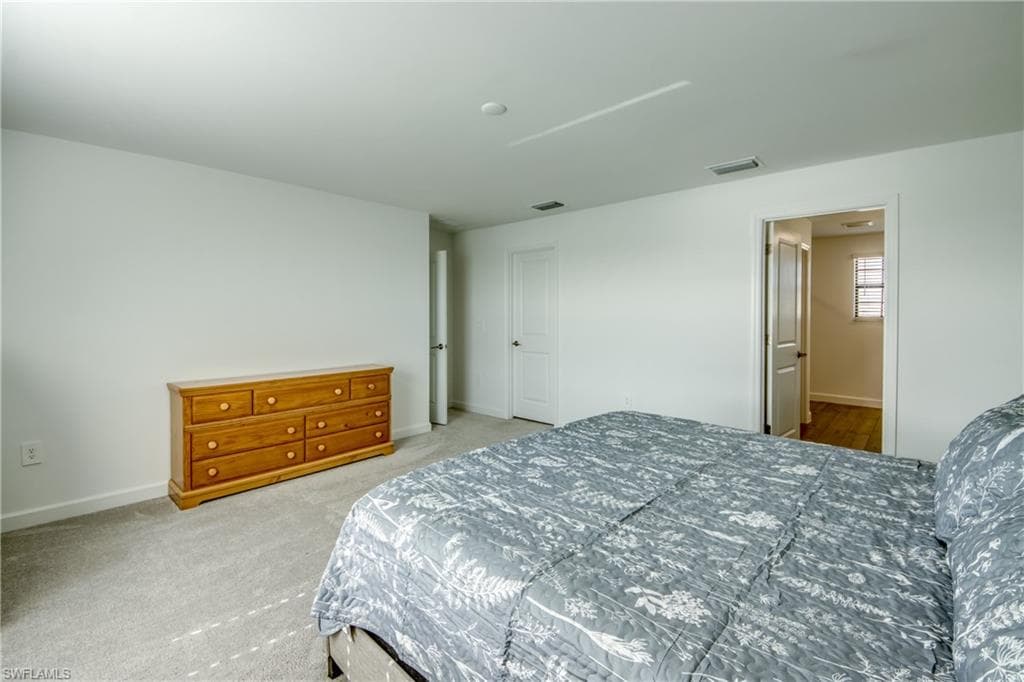 Carpeted bedroom featuring baseboards