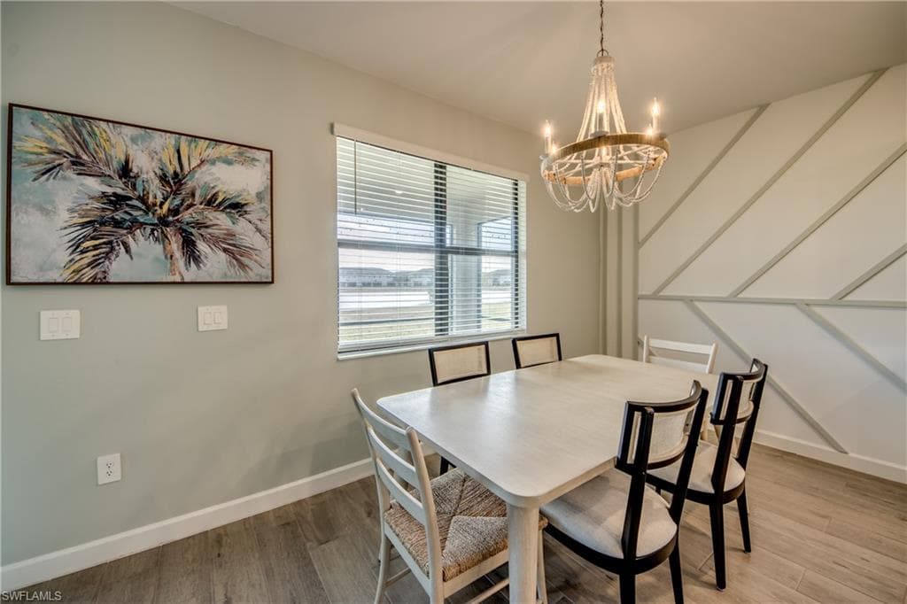 Dining room with wood finished floors and a chandelier