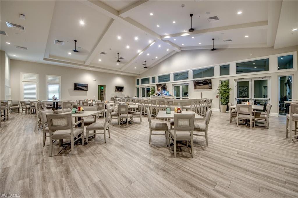 Dining area featuring high vaulted ceiling, recessed lighting, light wood-style flooring, ceiling fan, and beam ceiling