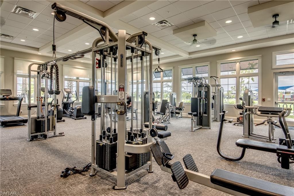 Gym with a drop ceiling, a high ceiling, and recessed lighting