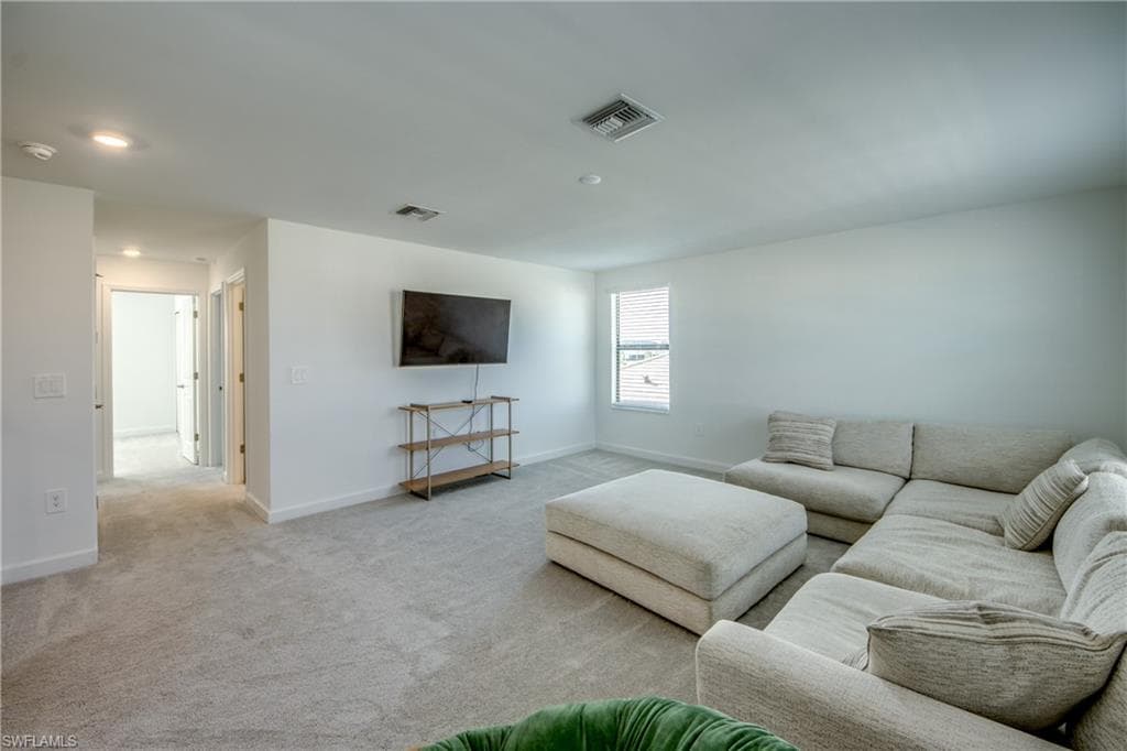 Carpeted living area with baseboards
