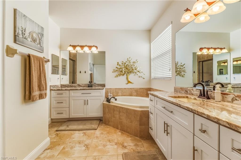 Full bathroom with a garden tub, two vanities, and a shower stall