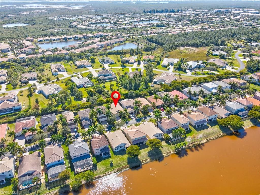 Aerial view of property and surrounding area with a large body of water and nearby suburban area