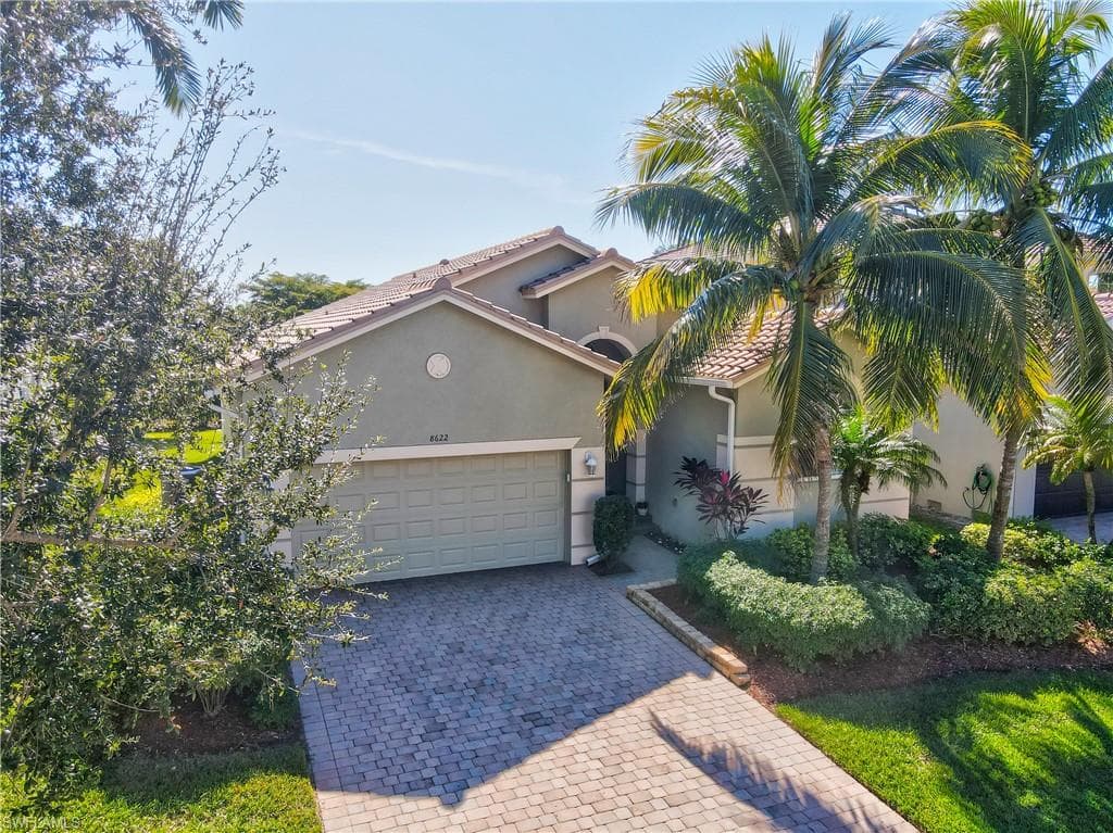 Mediterranean / spanish house with stucco siding, decorative driveway, a garage, and a tiled roof