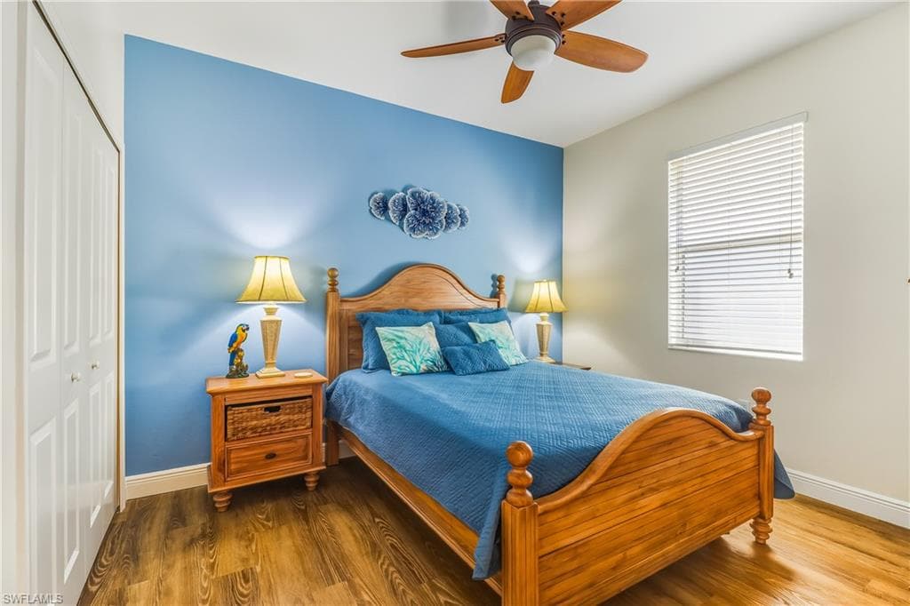 Bedroom with a closet, wood finished floors, and ceiling fan