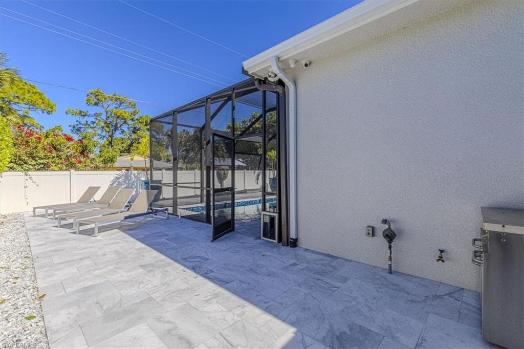 Fenced backyard with a lanai, a patio area, and a sunroom