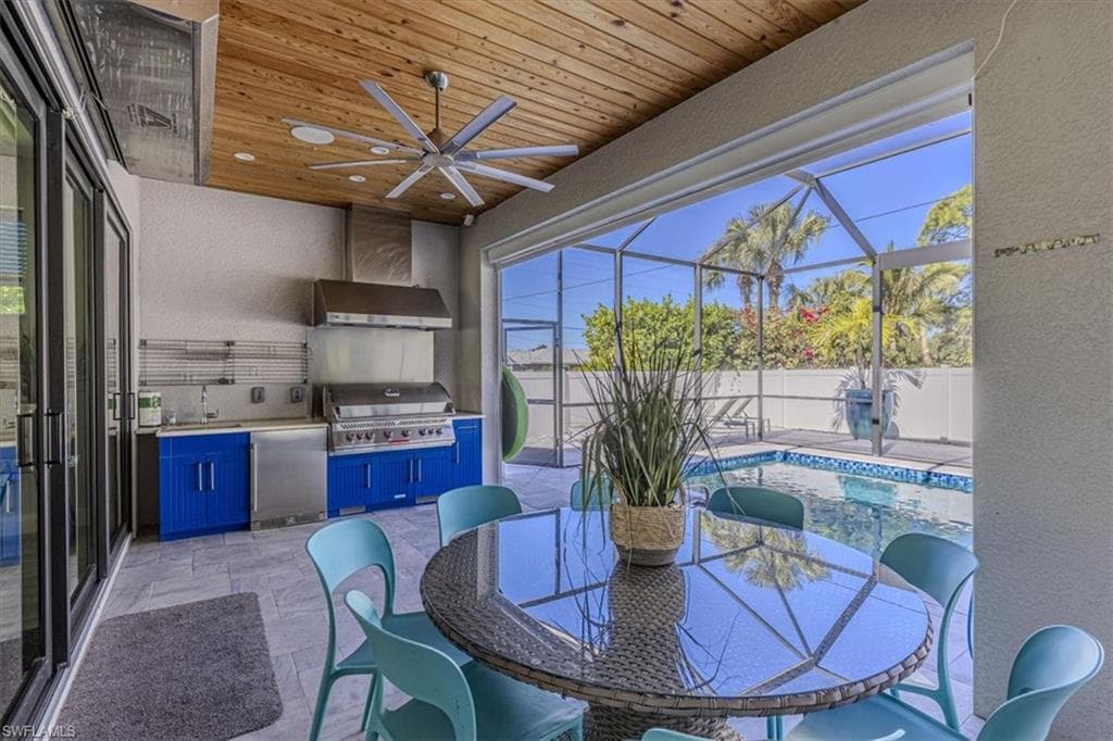 Fenced backyard featuring area for grilling, ceiling fan, a lanai, a patio area, and a sunroom