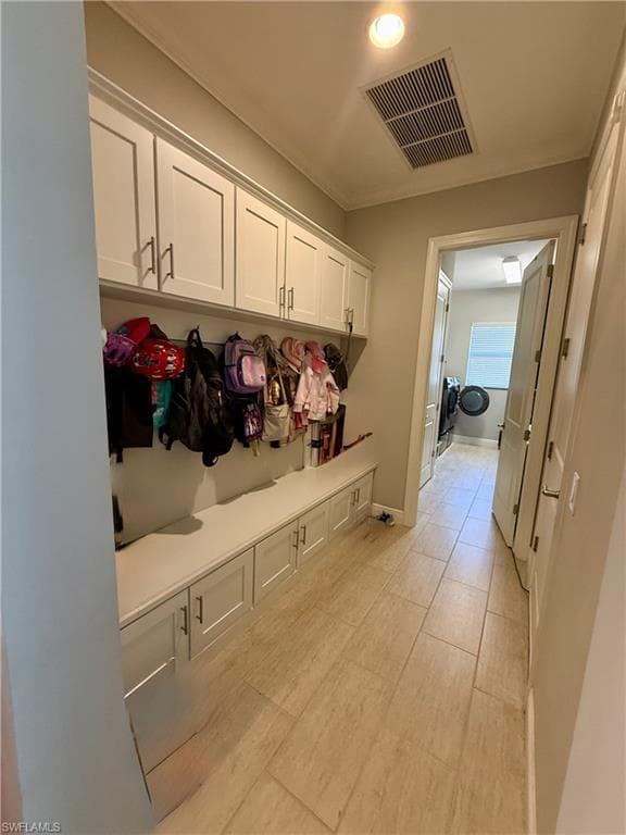 Mudroom with baseboards and crown molding