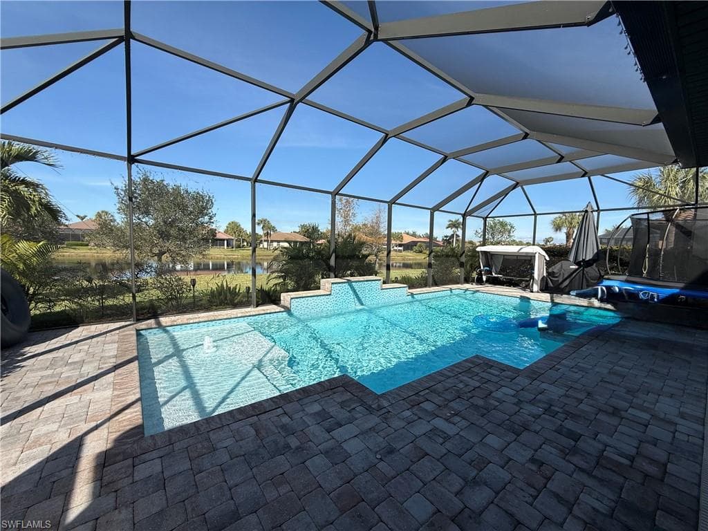 Swimming pool featuring a sunroom, a lanai, and a patio