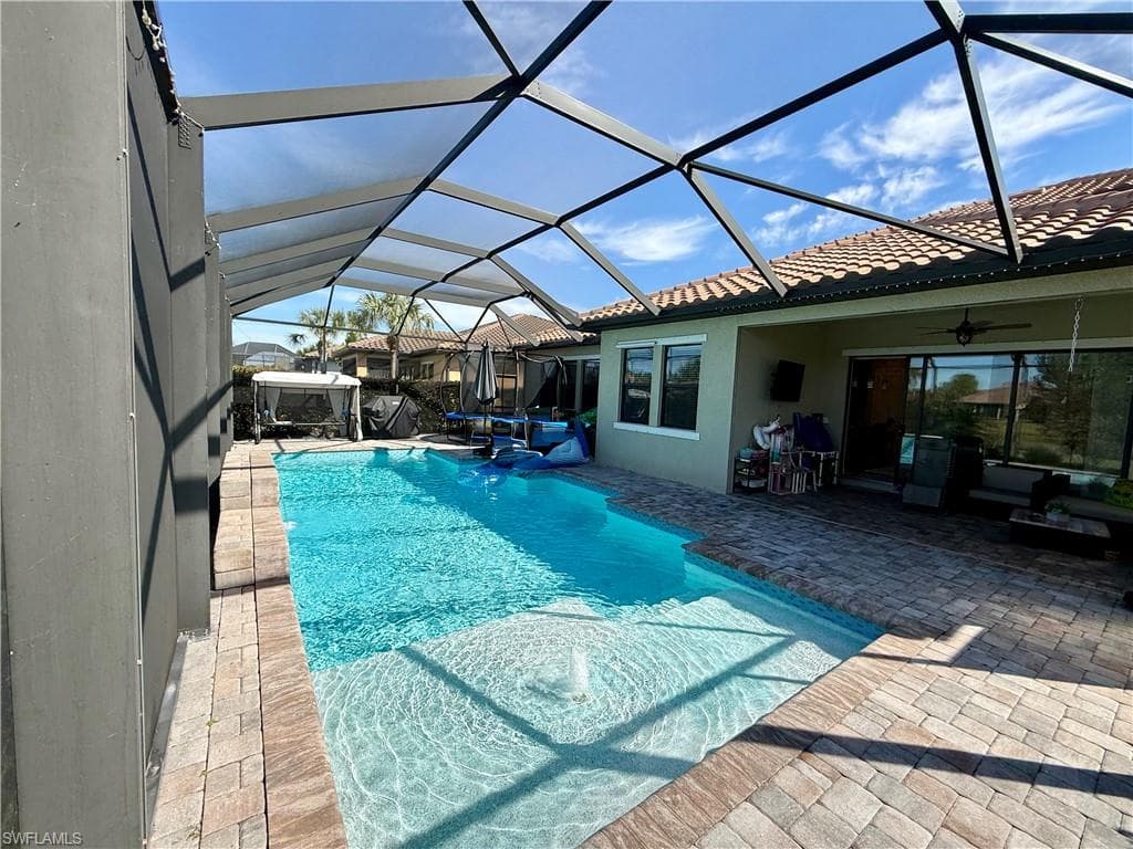Swimming pool with a sunroom, a patio, and a lanai
