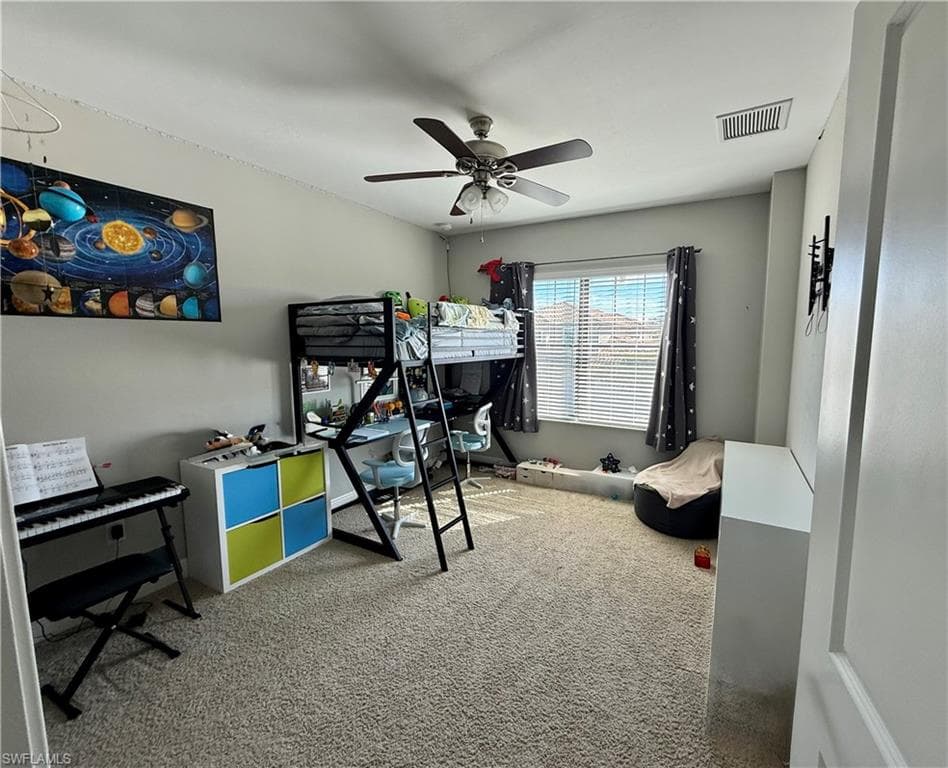 Carpeted bedroom featuring ceiling fan