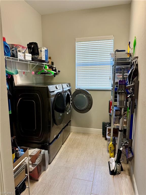 Laundry room featuring independent washer and dryer and baseboards