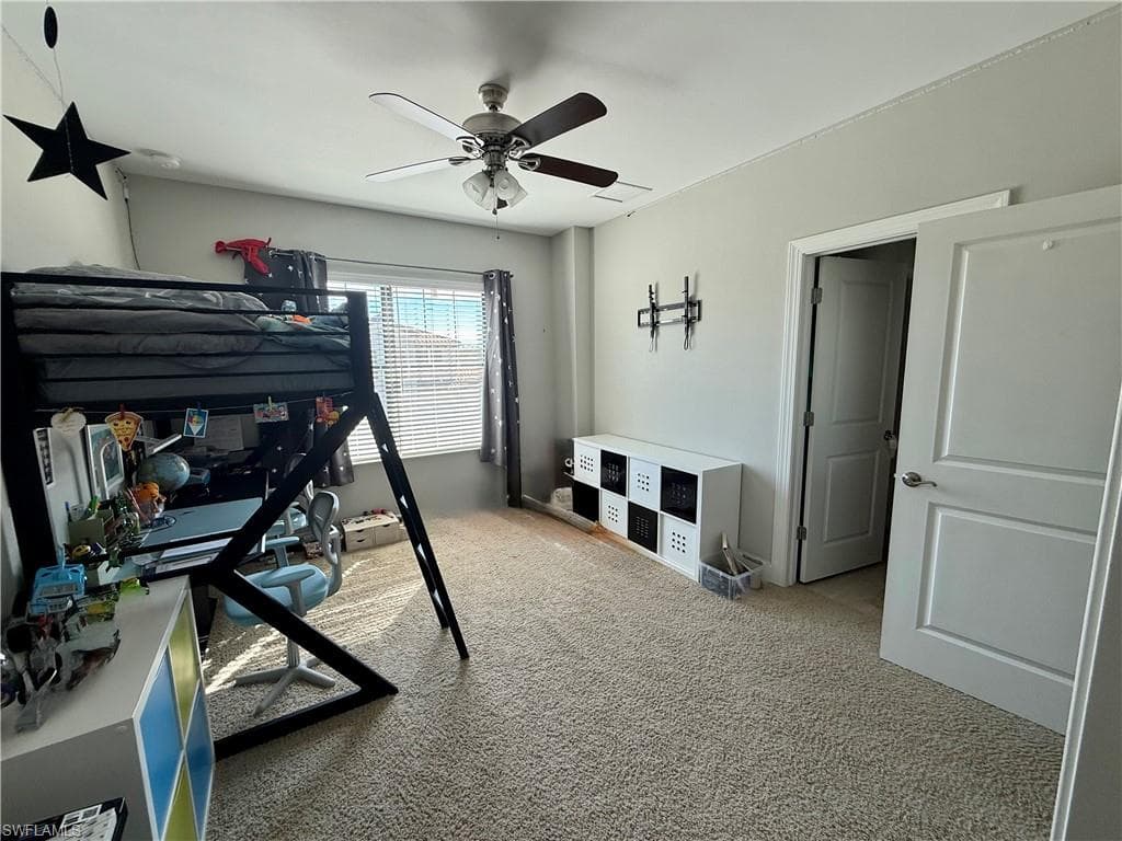 Bedroom featuring light colored carpet and ceiling fan