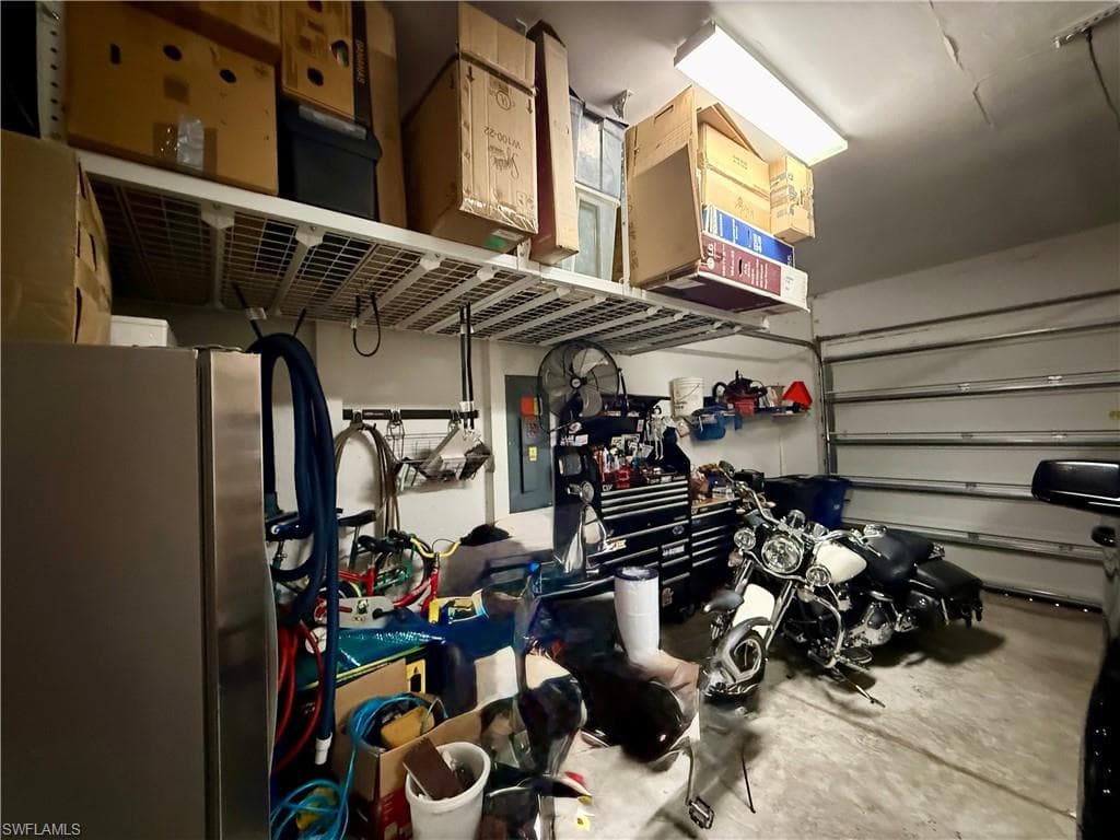Garage featuring freestanding refrigerator and electric panel