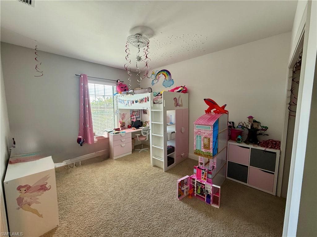 Bedroom featuring an office area and light carpet