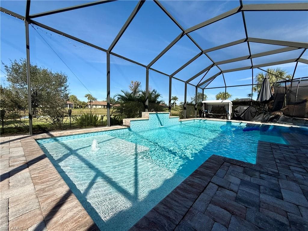 Outdoor pool featuring glass enclosure and a sunroom