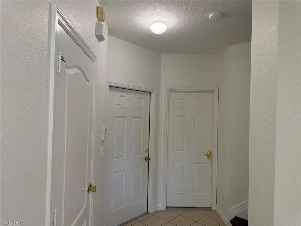 Tiled Entry Foyer. From the Right 1/s Bath, Entry Room, Door to the Garage